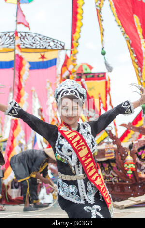 Unidentified young girl perform Traditional dance inside the  Bajau's boat called Lepa-Lepa decorated with colorfull Sambulayang flag during Regatta. Stock Photo