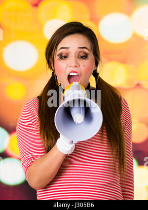 Closeup portrait of female clown mime screaming with a megaphone Stock Photo