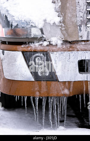 Mirror and fender of modern big rig beige semi truck in snow and ice on ...