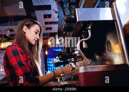 Bartender girl is making coffee in a bar Stock Photo