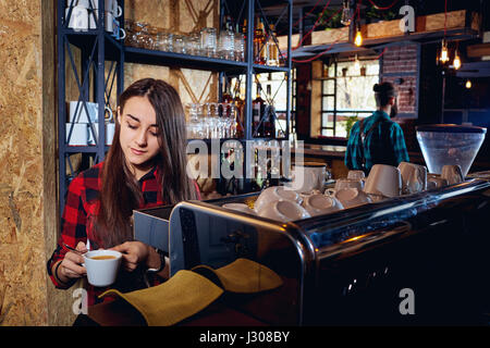 Bartender girl is making coffee in a bar Stock Photo