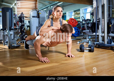 A couple doing push-ups on  floor in the gym sport club Stock Photo