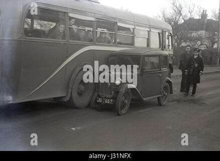 1950, a single-decker passenger bus in a collision with a small pre-ww2 Austin 7 motor car, England, UK. Stock Photo