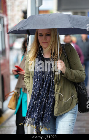 Hornsey, North London, UK. 1st May, 2017. A woman sheltering under umbrellas on a rainy day in Hornsey, North London. Credit: Dinendra Haria/Alamy Live News Stock Photo