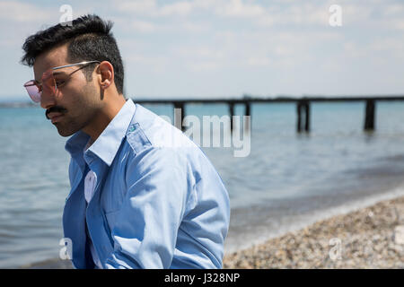 Handsome Indian man posing in a vacation context. Street fashion and style. Stock Photo