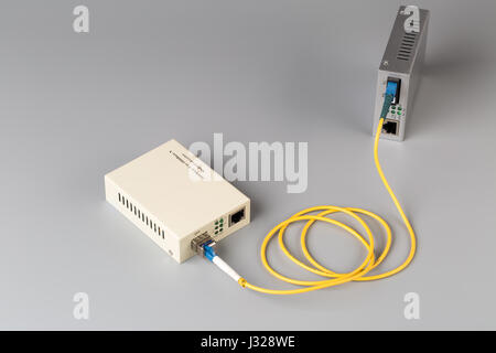 Two media converters connected by fiber cable Stock Photo