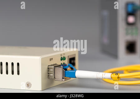 Two media converters connected by fiber cable Stock Photo