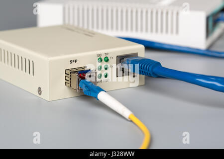 1Gbps optical media converter with SFP module connected to ethernet port SOHO router Stock Photo