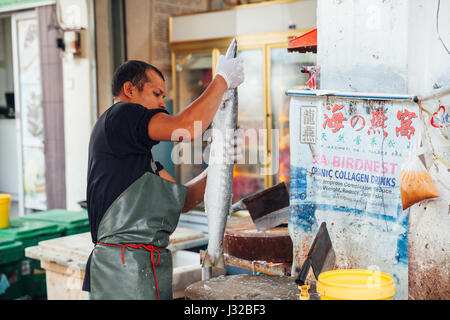 GEORGE TOWN, MALAYSIA - MARCH 23: Man prepare the fish for sale at the wet market on March 23, 2016 in George Town, Malaysia. Stock Photo