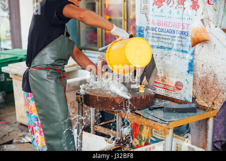 GEORGE TOWN, MALAYSIA - MARCH 23: Man prepare the fish for sale at the wet market on March 23, 2016 in George Town, Malaysia. Stock Photo