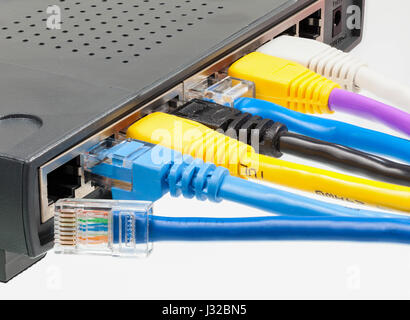 Plugs on cat5e ethernet cables plugged into a network router Stock Photo