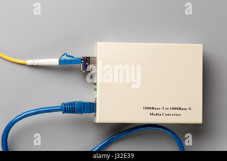 1Gbps optical media converter with SFP module connected to fiber patch cord and copper patch cord Stock Photo