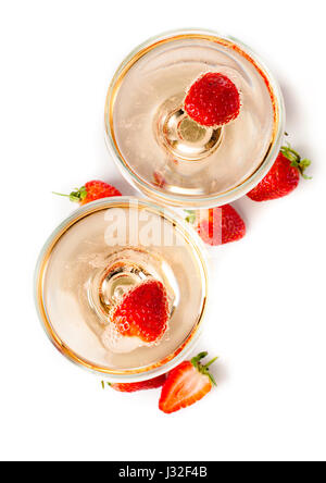 Two glasses of cold champagne with strawberries on a white background, isolated, close-up Stock Photo