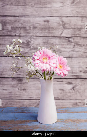 pink gerbera in white vase with wooden background Stock Photo