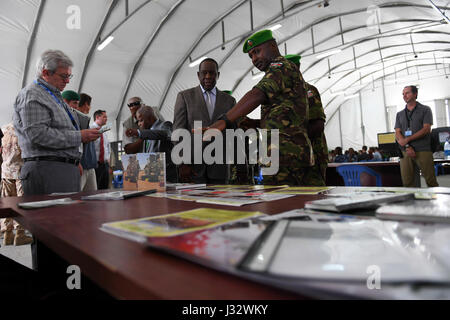 The Special Representative of the Chairperson of the African Union Commission (SRCC) for Somalia, Ambassador Francisco  Madeira (second from right), and the Head of  United Nations Support Office in Somalia (UNSOS), Hubert Price (left) inspect a desk with exhibited reading materials on how to counter Improvised Explosive Devices (IEDs). This was during a seminar on countering IEDs in Mogadishu, Somalia on February 6, 2017. AMISOM Photo / Omar Abdisalan Stock Photo