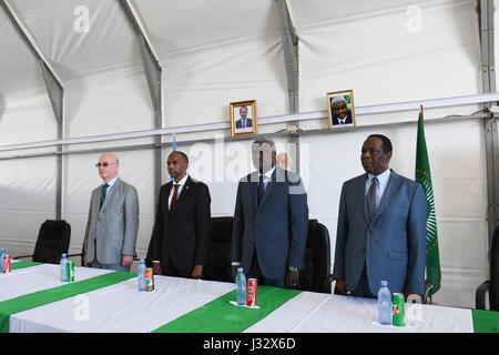 The African Union Commissioner for Peace and Security, Ambassador Smail Chergui (left), the Prime Minister of Somalia, Hassan Ali Kheyre (2nd left), The Chairperson of the African Union Commission, H.E Moussa Faki Mahamat (2nd right) and the Special Representative of the AU in Somalia Ambassador Francisco Madeira (right), stand for the African Union anthem. This was during the Chairperson's meeting with AU staff in Somalia during his first visit to the country on March 18, 2017. AMISOM Photo/Omar Abdisalan Stock Photo