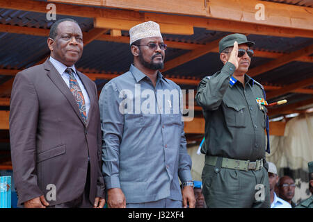 The Special Representative of the African Union Commission Chairperson (SRCC) for Somalia, Ambassador Francisco Madeira (left), the President of Jubbaland Administration (IJA) Ahmed Mohamed Islam (center) and the Somali Police Commissioner General Abdihakim Dahir Saaid, (right), at a guard of honour for the new  police recruits at a training center in Kismayo during passing out parade ceremony on April 24, 2017. AMISOM Photo Stock Photo