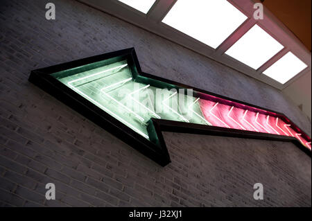 Arrow made of neon on a brick wall Stock Photo