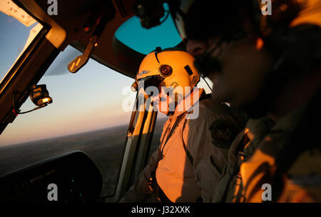 Air interdiction agents with the U.S. Customs and Border Protection, Air and Marine Operations, looks out from an A-Star helicopter over the Houston Air Unit in Conroe, Texas, as CBP prepares to provide security during this coming weekend's Super Bowl 51, Jan. 30, 2017. Additional flight time was taken for a flyovers of NRG Stadium and downtown Houston. U.S. Customs and Border Protection Photo by Glenn Fawcett Stock Photo