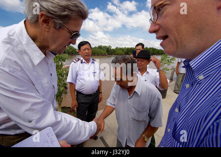 U.S. Secretary of State John Kerry shakes hands with 70-year-old Vo Ban Tam - who was part of a team that attacked the Secretary's Swift Boat on February 28, 1969, prompting the Secretary to kill his 24-year-old friend and fellow soldier, Ba Thanh.  The Secretary and Vo Ban Tam met on January 14, 2017, at the Nam Can Boat and Bus Station in Nam Can, Vietnam, while the Secretary visited the place where he started his career in public service as a U.S. Navy officer, and learned about war reconciliation efforts and work to curb environmental damage in the broader Mekong River Delta. Stock Photo