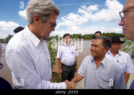 U.S. Secretary of State John Kerry shakes hands with 70-year-old Vo Ban Tam - who was part of a team that attacked the Secretary's Swift Boat on February 28, 1969, prompting the Secretary to kill his 24-year-old friend and fellow soldier, Ba Thanh. The Secretary and Vo Ban Tam met on January 14, 2017, at the Nam Can Boat and Bus Station in Nam Can, Vietnam, while the Secretary visited the place where he started his career in public service as a U.S. Navy officer, and learned about war reconciliation efforts and work to curb environmental damage in the broader Mekong River Delta. Stock Photo