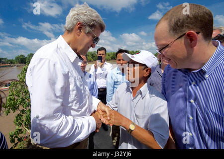 U.S. Secretary of State John Kerry shakes hands with 70-year-old Vo Ban Tam - who was part of a team that attacked the Secretary's Swift Boat on February 28, 1969, prompting the Secretary to kill his 24-year-old friend and fellow soldier, Ba Thanh. The Secretary and Vo Ban Tam met on January 14, 2017, at the Nam Can Boat and Bus Station in Nam Can, Vietnam, while the Secretary visited the place where he started his career in public service as a U.S. Navy officer, and learned about war reconciliation efforts and work to curb environmental damage in the broader Mekong River Delta. Stock Photo