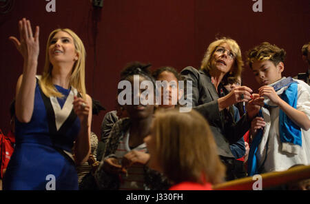 Ivanka Trump, daughter of U.S. President Donald Trump, left,  and U.S. Secretary of Education Betsy DeVos, right,  assists a student with a Rope Core Coding activity during the Celebrating Women’s History Month – Getting Excited About STEM event at the Smithsonian's National Air and Space Museum, Tuesday, March 28, 2017 in Washington, DC. Rope Core Coding consists of beads and wires where a 1 in binary code is programmed by threading the wire through the bead and a zero in binary code is coded by threading the wire around the bead. This coding method was used by Margaret Hamilton's team at MIT