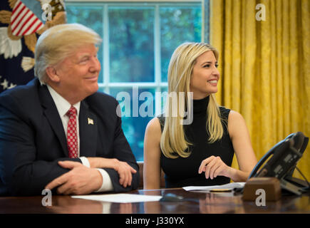 President Donald Trump, joined by First Daughter Ivanka Trump talks with NASA astronauts Peggy Whitson and Jack Fischer onboard the International Space Station Monday, April 24, 2017 from the Oval Office of the White House in Washington. The President congratulated Whitson for breaking the record for cumulative time spent in space by a U.S. astronaut. The President and First Daughter were also joined by NASA astronaut Kate Rubins and discussed with the three astronauts what it is like to live and work on the orbiting outpost as well as the importance of STEM.  Photo Credit: (NASA/Bill Ingalls) Stock Photo