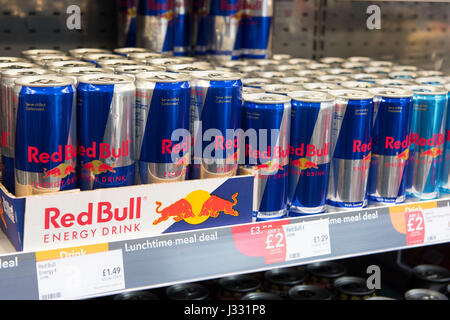 Cans of Red Bull on display for sale on a supermarket shelf. Stock Photo