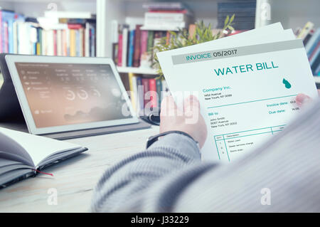 Man holds invoice of water usage Stock Photo