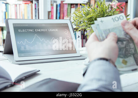 Electric energy usage application made in graphic program and man holding money Stock Photo