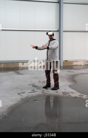 Architect with VR visor exploring industrial building environment - empty space with room for your projection visuals or text Stock Photo