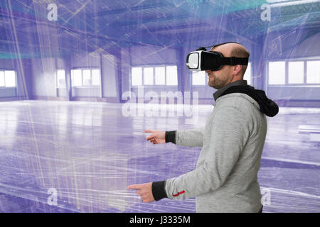 Architect with VR visor exploring industrial building environment with blueprint lines overlaying the real scenario Stock Photo