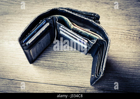 open black woman wallet with money and id cards on the wooden table Stock Photo