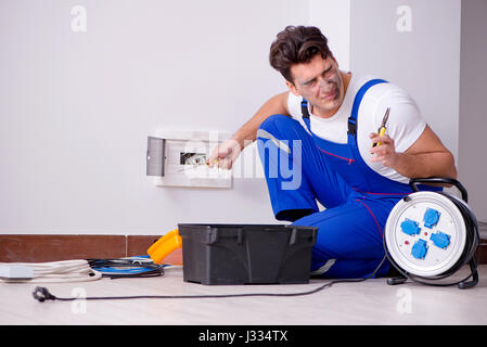 Funny Man doing electrical repairs at home Stock Photo
