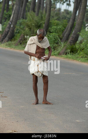 Illustrative image. Pondicherry, Tamil Nadu, India - April 14, 2014. Portrait of senior indian man in traditional costume. Poor men sad smiling sittin Stock Photo