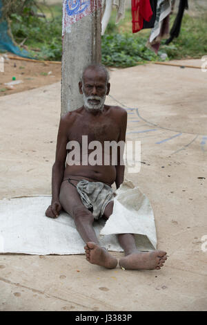 Illustrative image. Pondicherry, Tamil Nadu, India - April 14, 2014. Portrait of senior indian man in traditional costume. Poor men sad smiling sittin Stock Photo