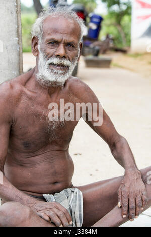 Illustrative image. Pondicherry, Tamil Nadu, India - April 14, 2014. Portrait of senior indian man in traditional costume. Poor men sad smiling sittin Stock Photo