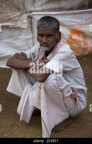 Illustrative image. Pondicherry, Tamil Nadu, India - April 14, 2014. Portrait of senior indian man in traditional costume. Poor men sad smiling sittin Stock Photo