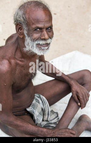 Illustrative image. Pondicherry, Tamil Nadu, India - April 14, 2014. Portrait of senior indian man in traditional costume. Poor men sad smiling sittin Stock Photo