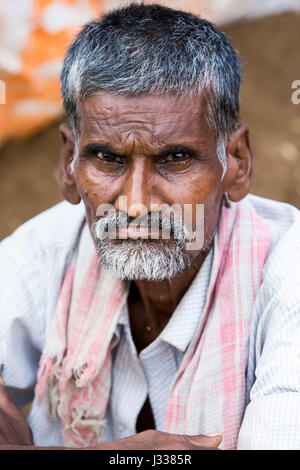 Illustrative image. Pondicherry, Tamil Nadu, India - April 14, 2014. Portrait of senior indian man in traditional costume. Poor men sad smiling sittin Stock Photo