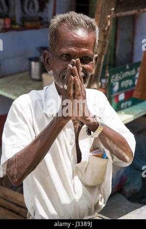 Illustrative image. Pondicherry, Tamil Nadu, India - April 14, 2014. Portrait of senior indian man in traditional costume. Poor men sad smiling sittin Stock Photo