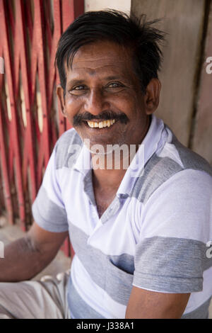 Illustrative image. Pondicherry, Tamil Nadu, India - April 14, 2014. Portrait of senior indian man in traditional costume. Poor men sad smiling sittin Stock Photo