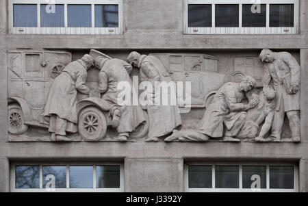 Road accident. Relief by Hungarian sculptor Laszlo Huvos (1930) on the north wing of the Art Deco building of the Budapest Workers Insurance Fund in Budapest, Hungary. The building, now used as the seat of the National Social Insurance Centre (OTI), was designed by Hungarian architects Marcell Komor and Dezso Jakab and built in 1913. The north wing was added by architect Aladar Sos in 1930-1931. Stock Photo