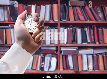 Paper documents stacked archive and stopwatch in male hand Stock Photo