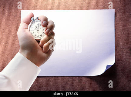 Blank sheet of paper and stopwatch in male hand Stock Photo