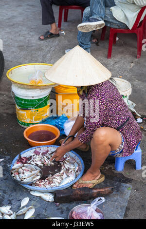 NHA TRANG, VIETNAM - JANUARY 20: Woman is preparing seafood for sale at the market street on January 20, 2016 in Nha Trang, Vietnam. Stock Photo