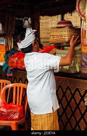 UBUD, INDONESIA - MARCH 2: Boy takes the offering box during the celebration before Nyepi (Balinese Day of Silence) on March 2, 2016 in Ubud, Indonesi Stock Photo