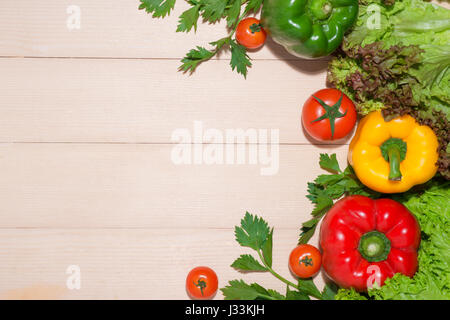 Open recipe book with fresh vegetables on wooden table. Stock Photo