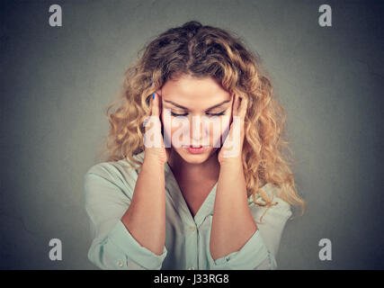 Closeup portrait sad young beautiful woman with worried stressed face expression looking down Stock Photo